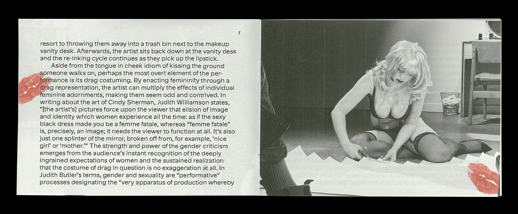 Pages five and six of A Ranic Kissing Floor zine, featuring a black and white image of a drag woman cutting out a lipstick prinnted kiss on the floor on the right. The left pages features black text printed on cool grey paper with a transparent kiss in red printed over the text on the upper left of the page.